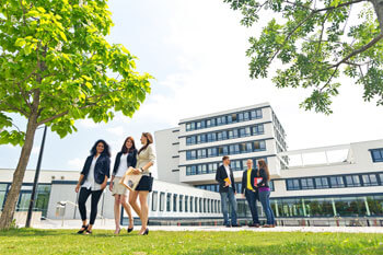 Studierende laufen ueber den Campus